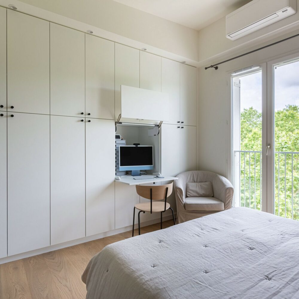 Chambre moderne avec bureau escamotable intégré dans un grand placard