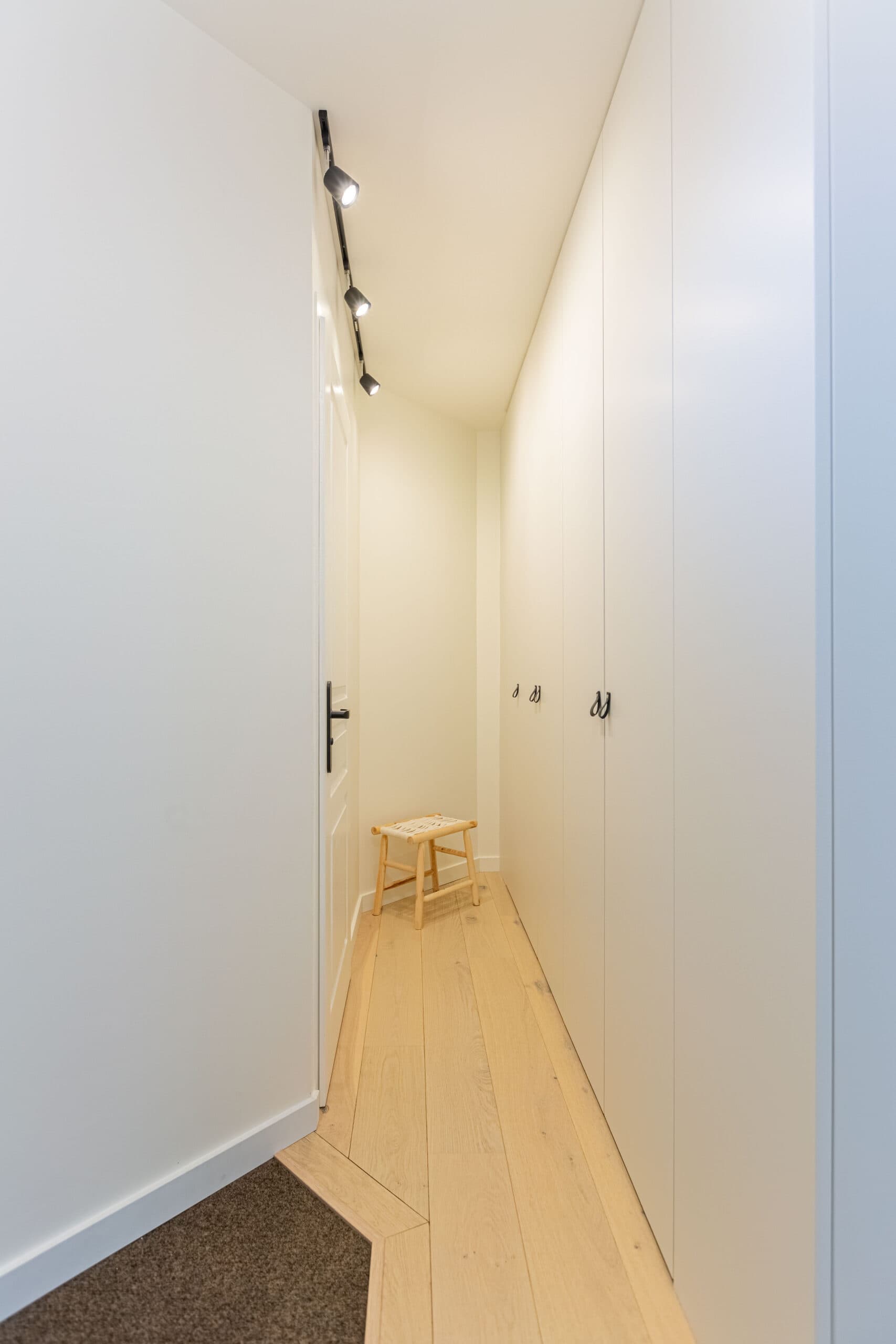 Couloir lumineux avec rangement blanc intégré et parquet en bois