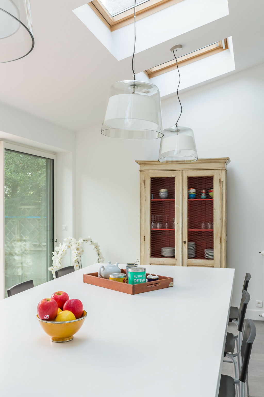 Cuisine ouverte avec îlot central et luminaires suspendus modernes.
