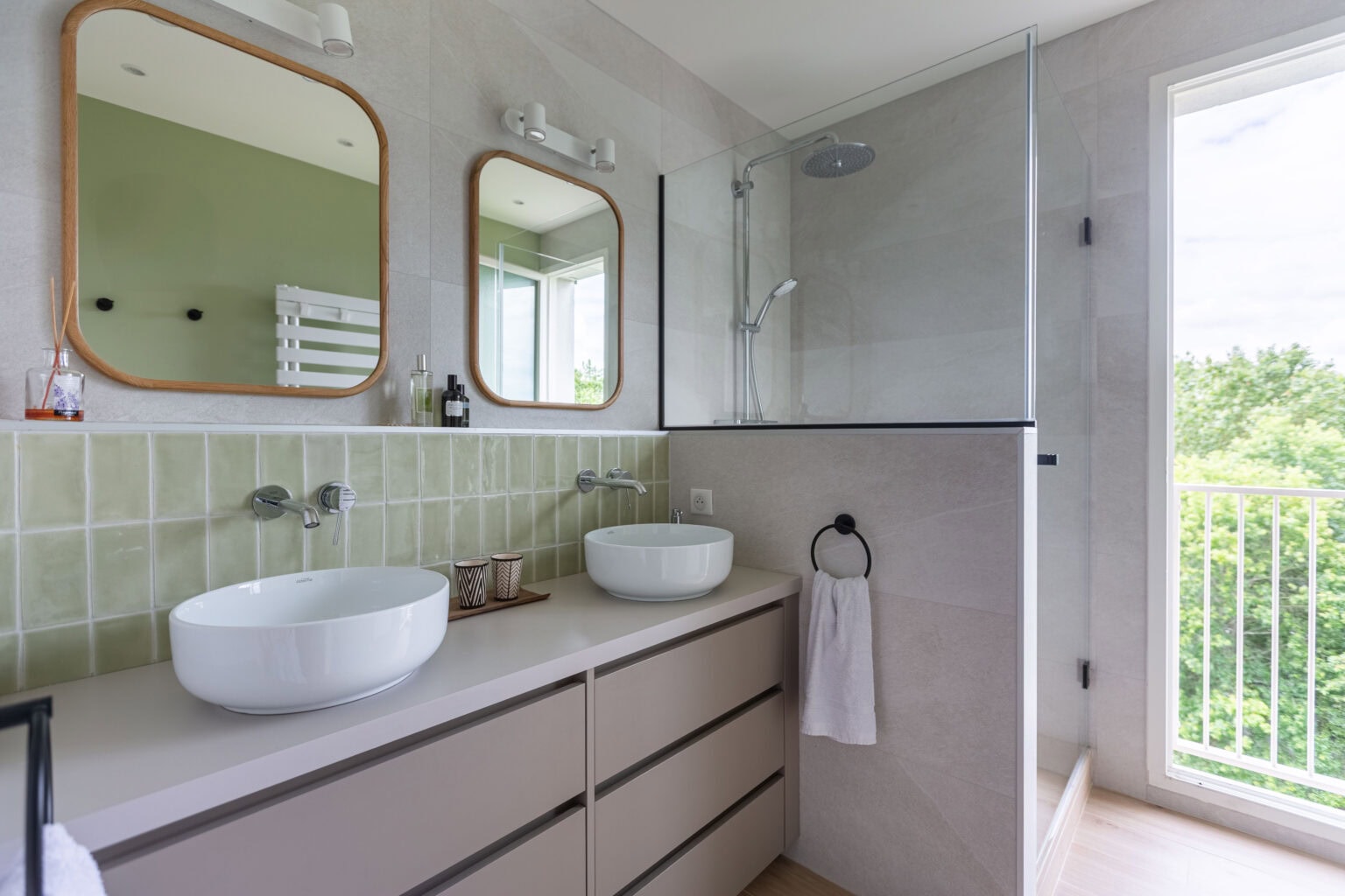 Salle de bain avec double vasque, miroirs en bois et douche à l’italienne avec paroi vitrée