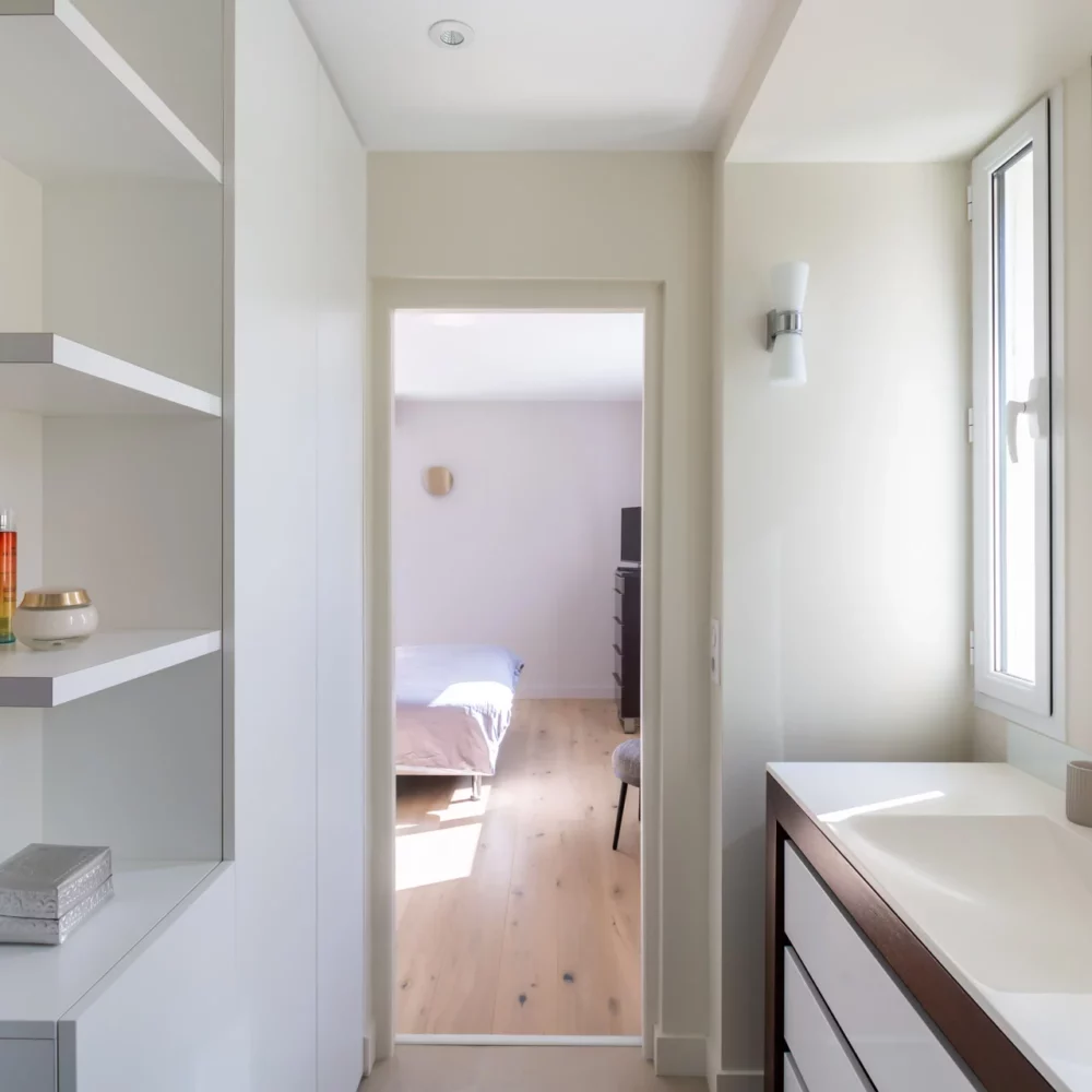 Salle de bain contemporaine avec rangements ouverts et meuble vasque moderne.