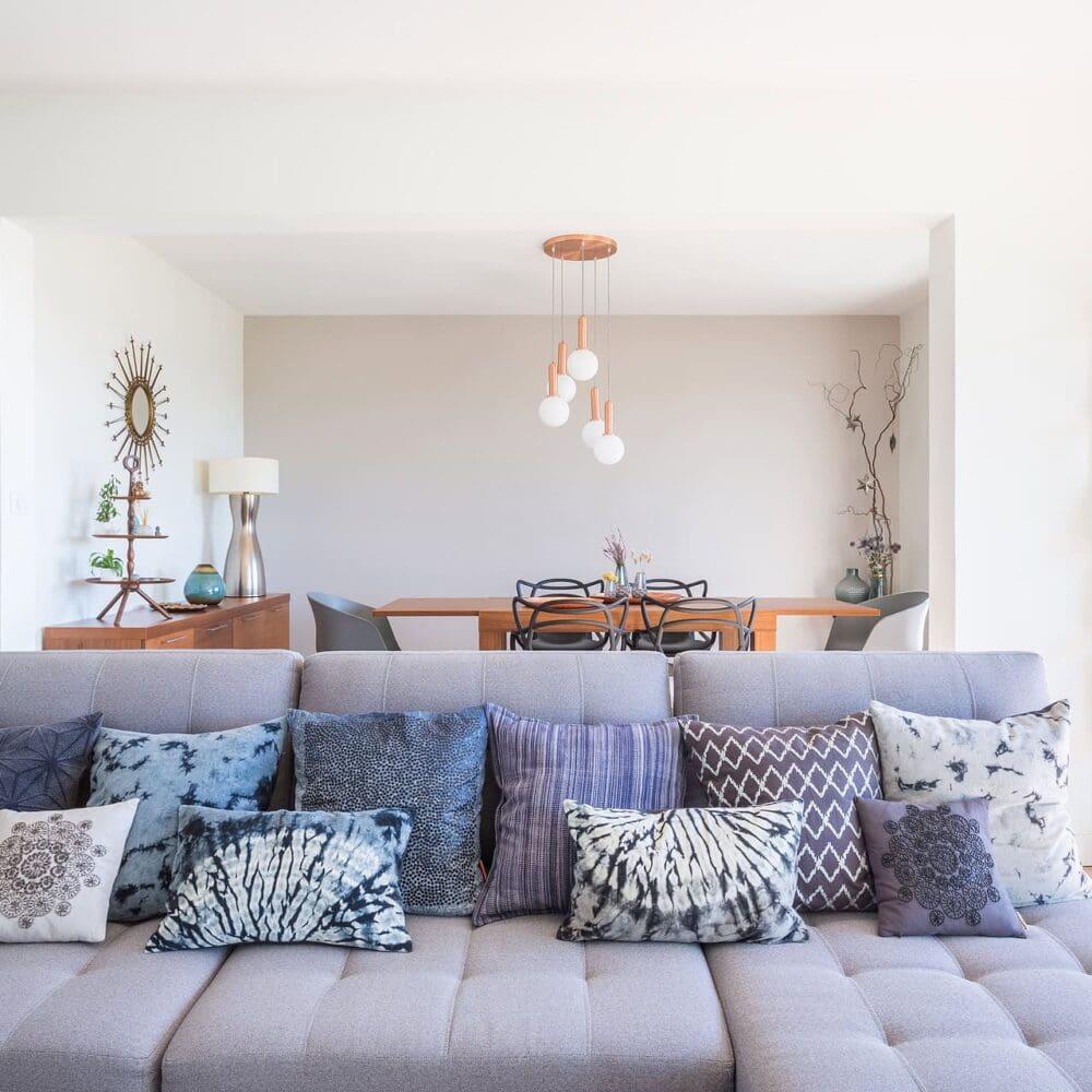 Salon moderne avec un canapé gris et des coussins aux motifs variés