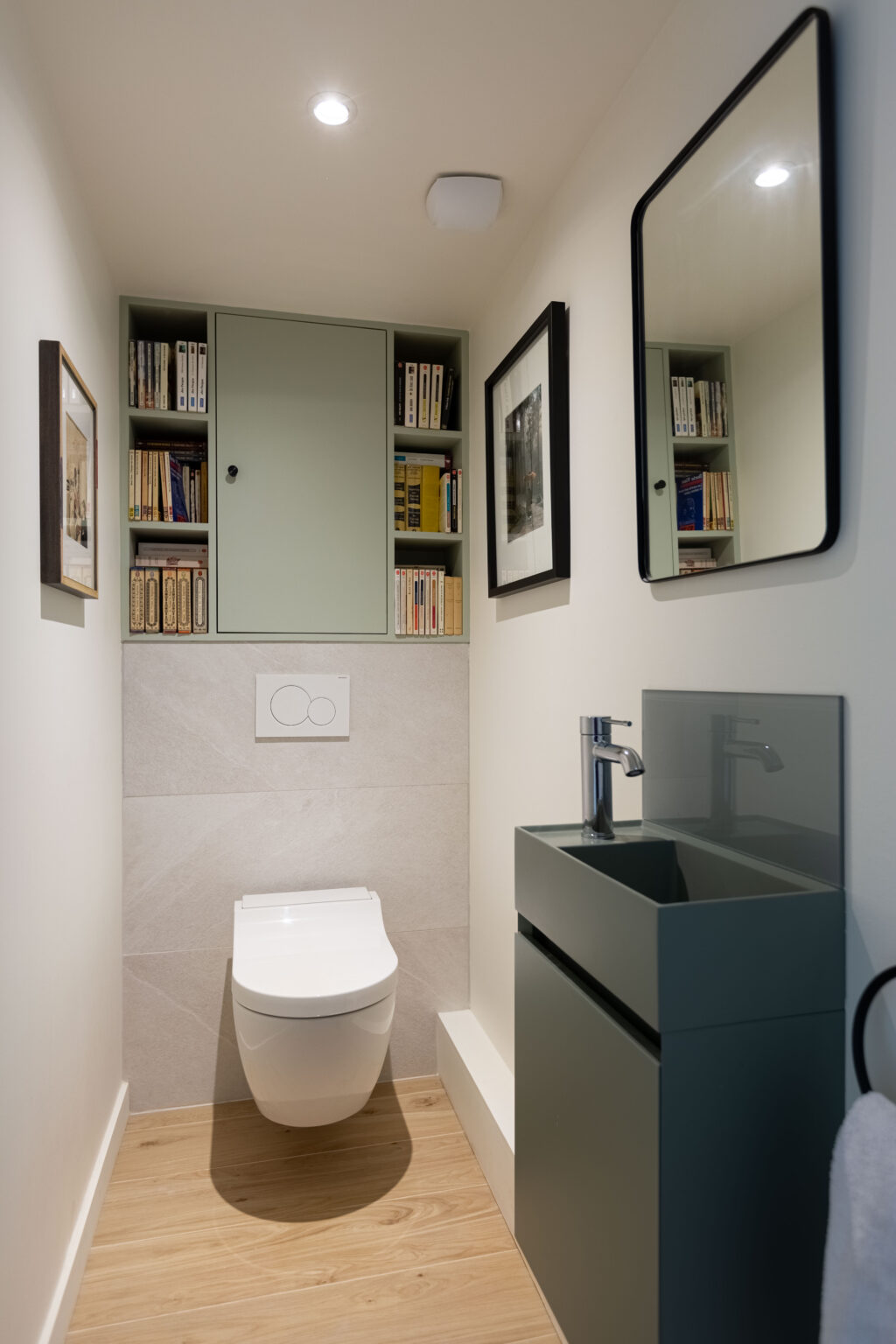 Toilettes modernes avec bibliothèque intégrée et meuble vasque vert