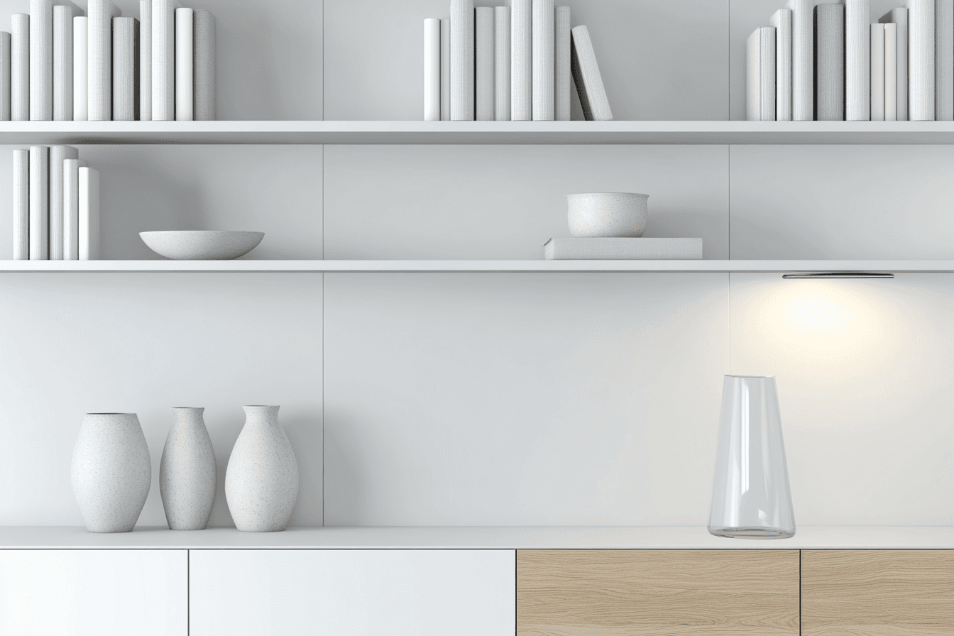 Commode encastrée blanche avec plante verte et lampe minimaliste.