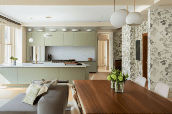 Mur vert sauge dans la cuisine jouxtant un salon aux tons neutres et papier peint floral