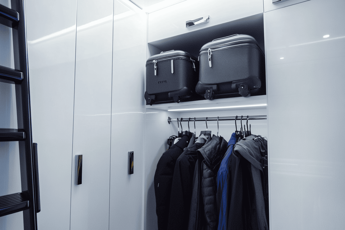 Valises et linge de maison stockés en hauteur dans un dressing bien agencé.